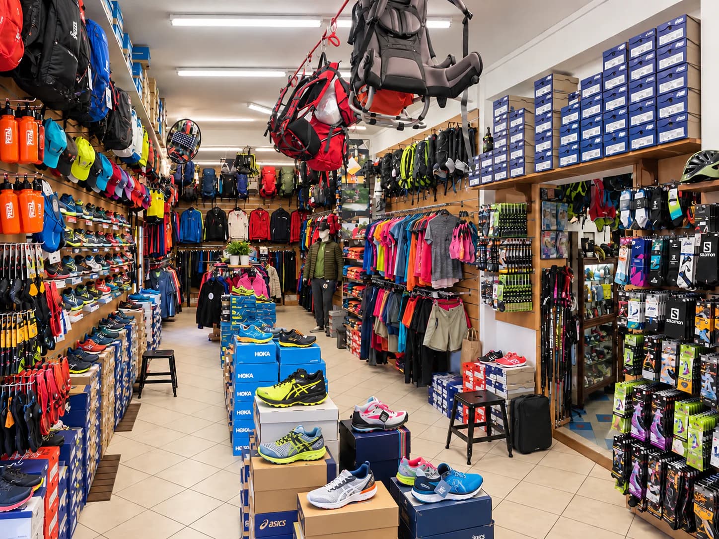 Chaussures de trail, sacs et accessoires outdoor exposés en boutique